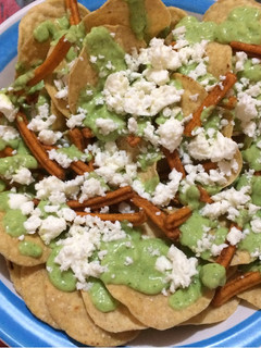 Una foto de Nachos con crema o dip de aguacate