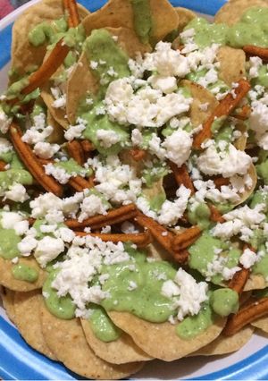 Una foto de Nachos con crema o dip de aguacate