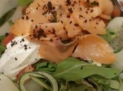 Una foto de ensalada de salmón ahumado y rúcula