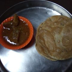 A picture of Chicken curry and puri.