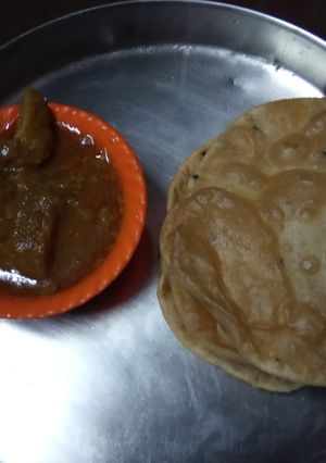 A picture of Chicken curry and puri.