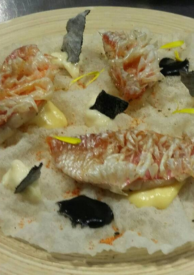 Una foto de Salmonetes con emulsión de mostaza y salsa de tinta
