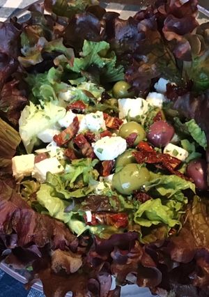 Une photo de Salade de batavia rouge aux tomates séchées,olives multicolores et feta grecque