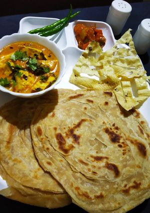 A picture of Dum paneer handi masala with Lachha Paratha.