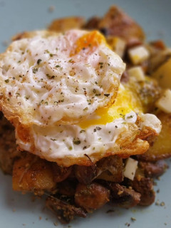 Una foto de Patatas y champiñones al pesto con provolone y huevo frito