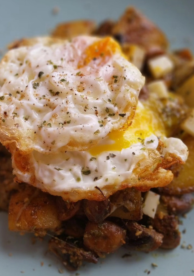 Una foto de Patatas y champiñones al pesto con provolone y huevo frito