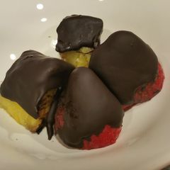 A picture of Fruit coated with dark crunchy chocolate.