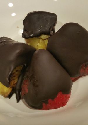 A picture of Fruit coated with dark crunchy chocolate.