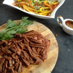 A picture of Jamaican pulled beef with brown sauce and pickled veg.