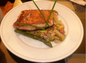 Una foto de Salmón rosado a la manteca negra con guarnición de panceta, puerro y esparrágos 