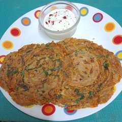 A picture of Classic Comfort Besan & Pyaz Lachha Paratha With A Bowl Of Curds.