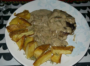 Una foto de Lomo o cuadril en salsa de champiñones con papas rústicas