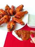 Alitas de pollo al horno con salsa Buffalo, acompañadas de salsa de queso azul