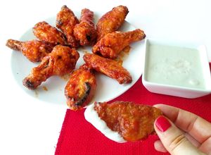 Una foto de Alitas de pollo al horno con salsa Buffalo, acompañadas de salsa de queso azul