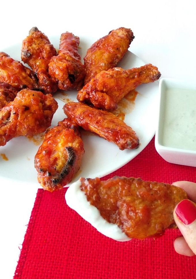 Una foto de Alitas de pollo al horno con salsa Buffalo, acompañadas de salsa de queso azul