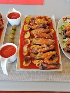 Una foto de Patatas bravas con alitas de pollo