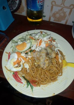 A picture of Spagetti with chicken and salad.