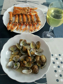 Una foto de Almejas con vino blanco ajo, perejil y unas cigalas a la plancha