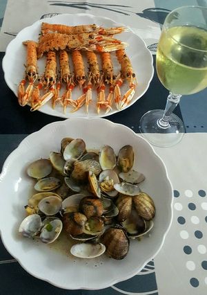 Foto principal de Almejas con vino blanco ajo, perejil y unas cigalas a la plancha