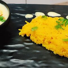 A picture of Onion rice with tadka raita.