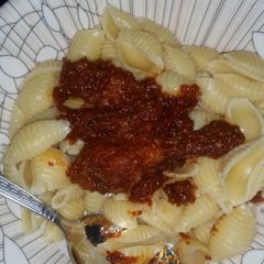 A picture of Boiled macaroni with chicken tomato paste stew.