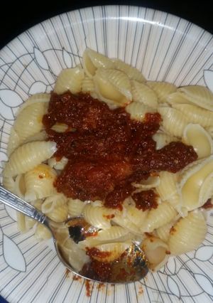 A picture of Boiled macaroni with chicken tomato paste stew.