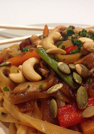 Una foto de Noodles de arroz con verduras, shiitake y frutos secos con soja y miel