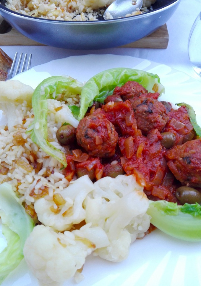 Una foto de Albóndigas en salsa de tomate al comino sobre arroz con coliflor