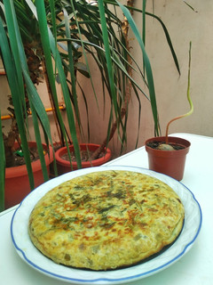 Una foto de Tortilla de cebolleta, pimiento verde y hojas de rabanito