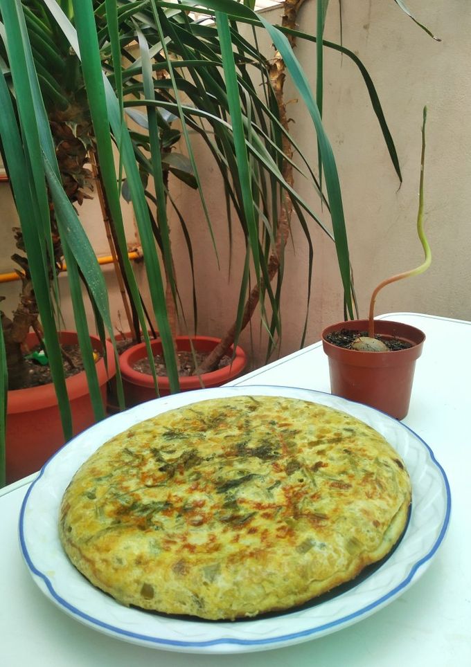 Una foto de Tortilla de cebolleta, pimiento verde y hojas de rabanito