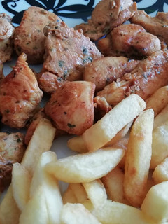 Una foto de Pinchitos de pollo en adobo y patatas fritas