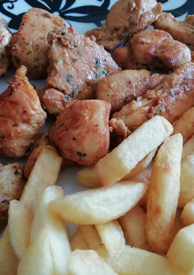 Una foto de Pinchitos de pollo en adobo y patatas fritas