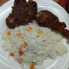 A picture of Fried chicken and vegetable rice.