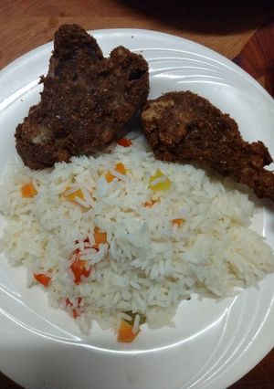 A picture of Fried chicken and vegetable rice.