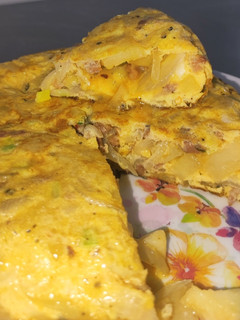 Una foto de Tortilla de patatas, chorizo, y cebollas