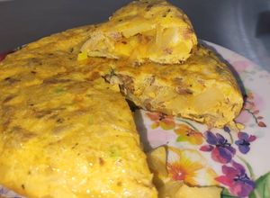 Una foto de Tortilla de patatas, chorizo, y cebollas