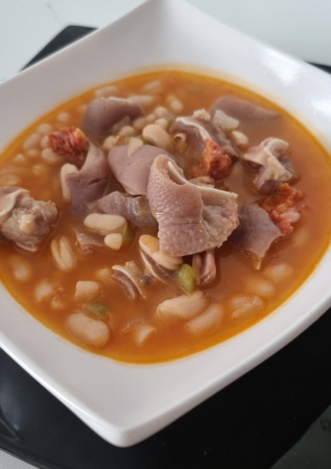 Una foto de Alubias blancas con oreja y chorizo al estilo de pepa