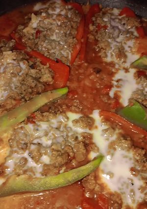 Una foto de 🌶️ Morrones rellenos en salsa con arroz 🍲