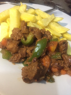 A picture of Stir n fry Beef served with fries.