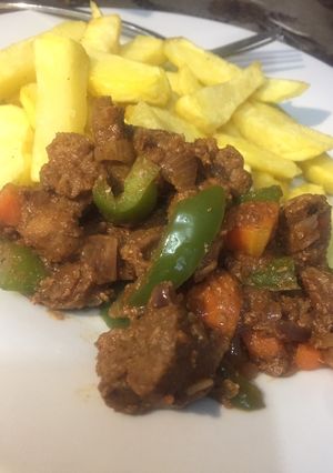 A picture of Stir n fry Beef served with fries.