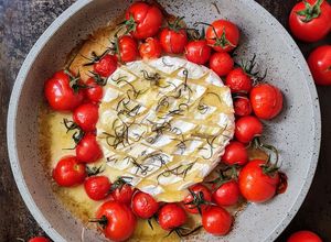 Una foto de Queso Camembert al ajo con tomatitos cherry y romero