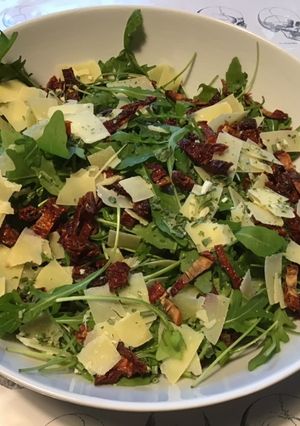 Une photo de Roquette aux tomates séchées,copeaux de comté affiné et herbes aromatiques