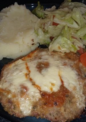 Una foto de Milanesa a la napolitana con puré y ensalada