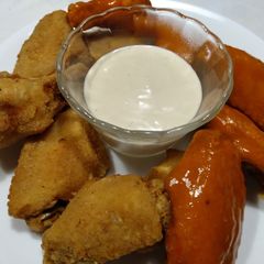 A picture of Crunchy pan-fried chicken wings with blue cheese dip.