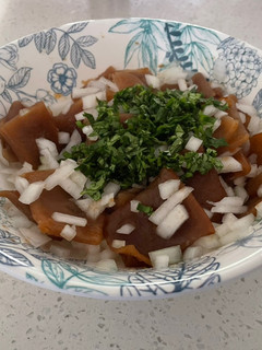 Una foto de Cochayuyo en ensalada con cebolla blanca y cilantro