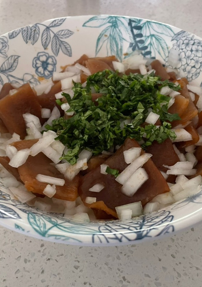 Una foto de Cochayuyo en ensalada con cebolla blanca y cilantro