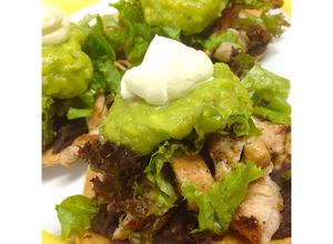Una foto de Tostadas mexicanas con pechuga grillada, guacamole y frijol refrito