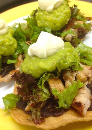 Una foto de Tostadas mexicanas con pechuga grillada, guacamole y frijol refrito