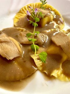 Foto di Ravioli con pasta alla zucca e ripieno di ricotta alla besciamella di funghi porcini