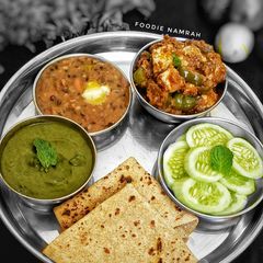 A picture of Punjabi Thali (dal makhani, paneer tikka gravy, mint chutney).